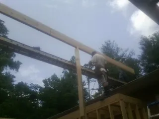 Carpenter setting a ridge beam over a new addition frame — Ice Dam Removal by Roofing Brothers in Center Barnstead