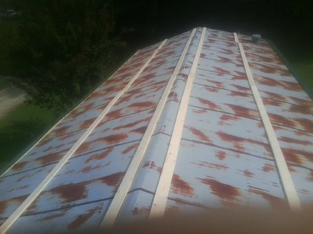 Rusted metal roof panels with new wood purlins before replacement — Storm Damage Roof Repair in Center Barnstead by Roofing Brothers