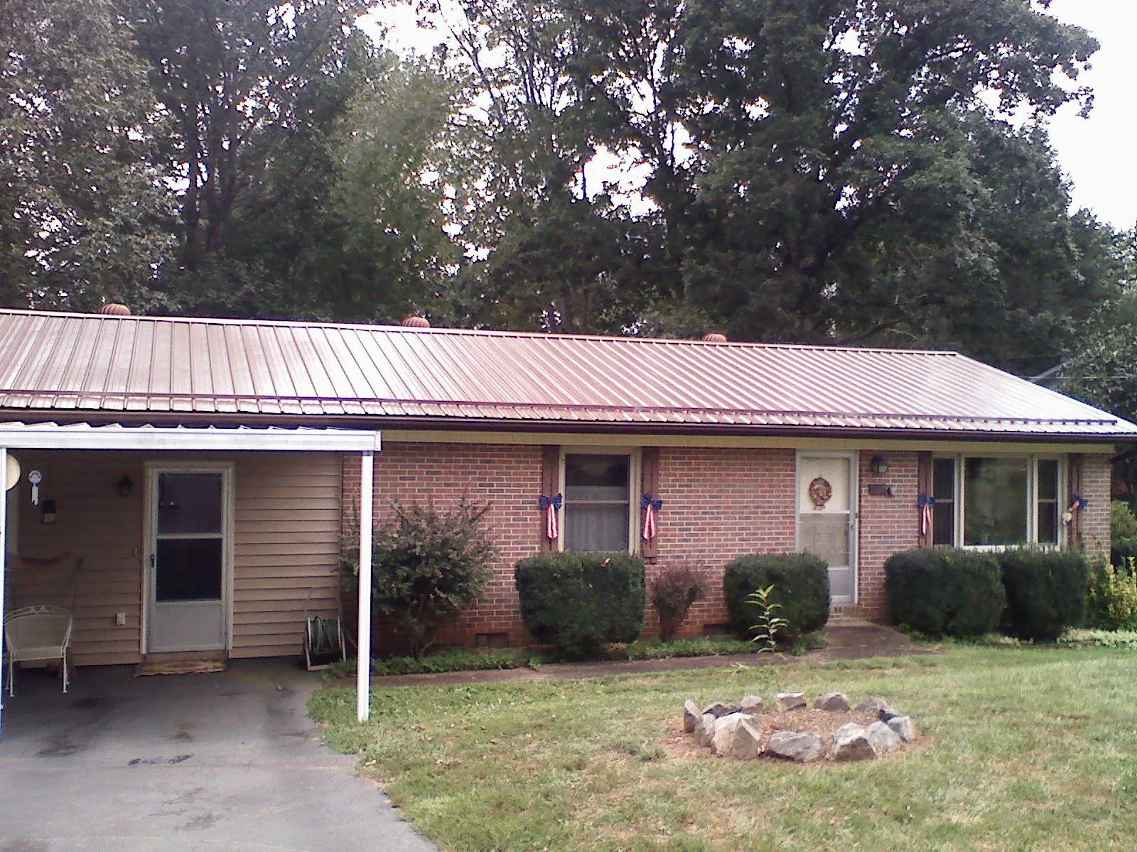 Bronze metal roof and carport on a brick ranch home — Roof Repair work by our crew in Center Barnstead